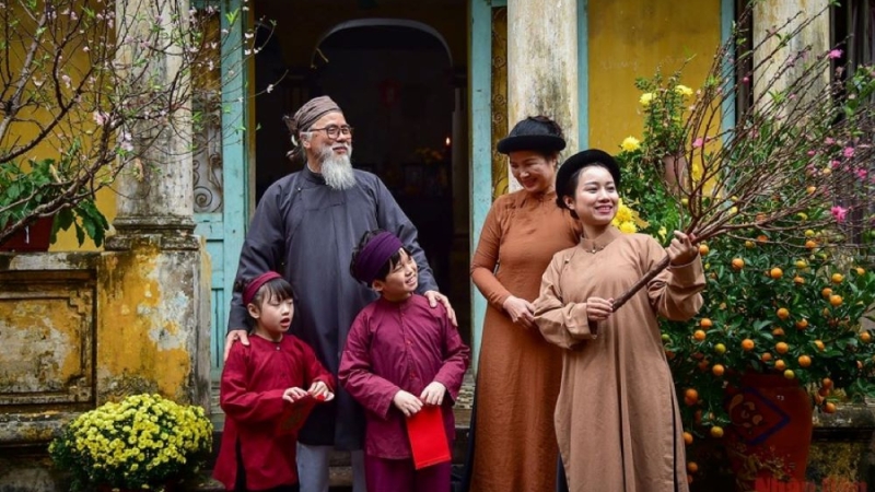 Ông bà cùng con cháu sum vầy bên cây mai và quất ngày xuân